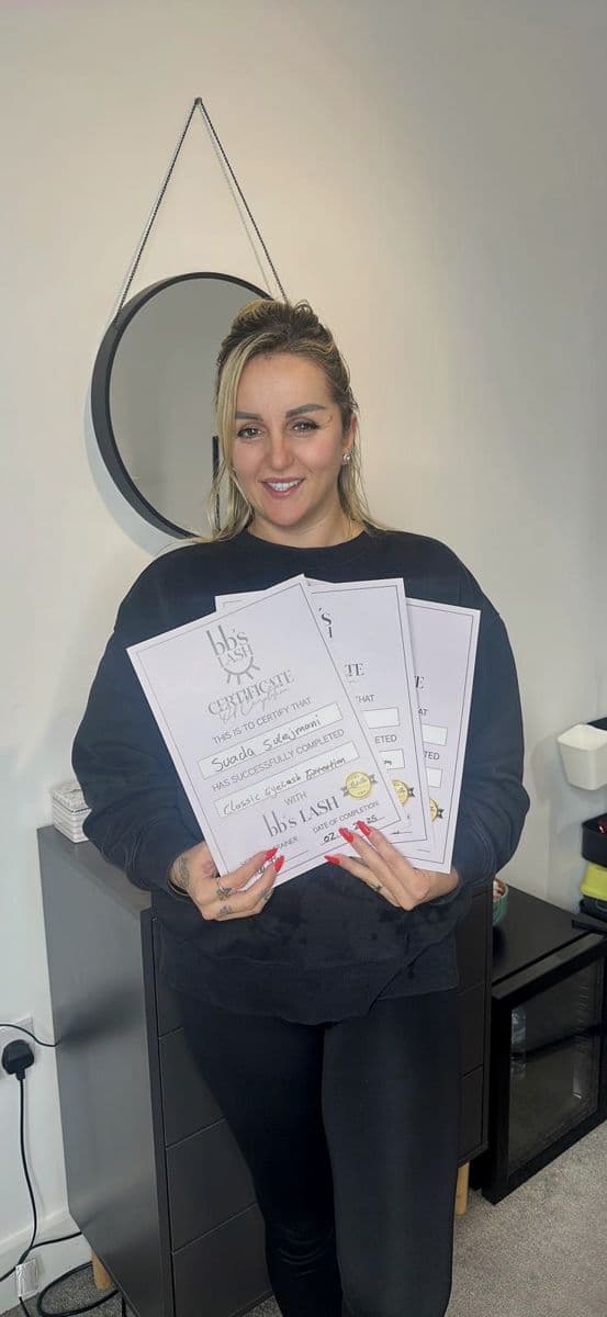 A graduate with her Classic Eyelash Extension certificates