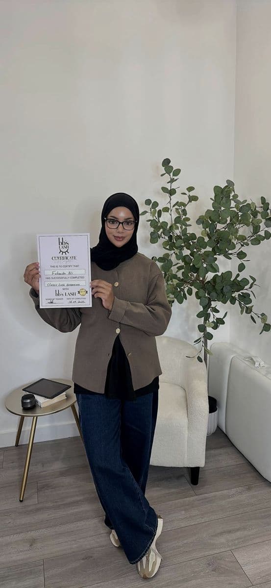 A graduate holding her Classic Lash Extensions certificate